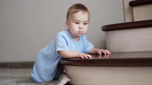 Smiling Infant Climbing a Staircase in a Home