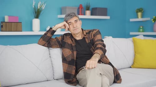 Contemplative Man Relaxing on Couch at Home