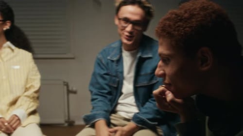 Four Young Adults Talking in a Group Indoors