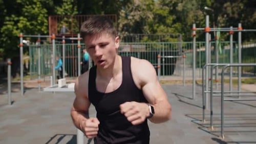 Muscular Man Shadow Boxing in Urban Park