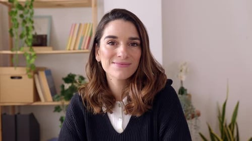 Portrait of Cheerful Young Adult Woman Looking at Camera Sitting at Home Office