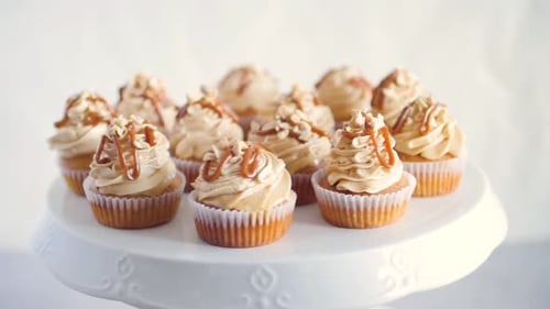 Caramel Frosted Cupcakes Rotating on a White Stand