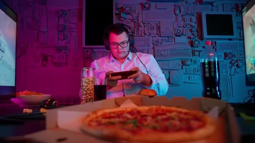 Programmer Playing Mobile Phone And Burger