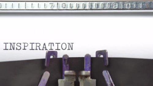 Inspiration word closeup being typing and centered on a sheet of paper on old vintage typewriter