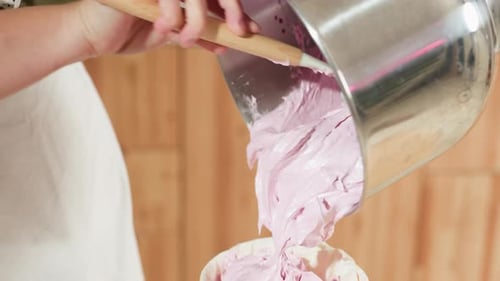 Baker Scrapes Fluffy Pink Dough From Mixing Bowl Into Piping Bag for Baking