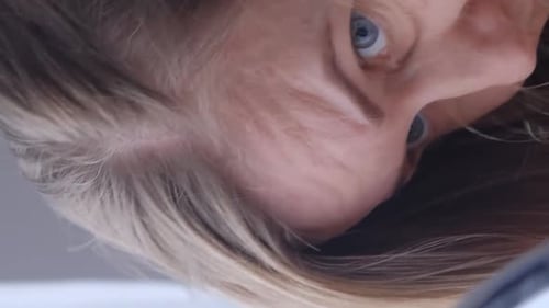 Woman Examining Face Close Up in Portrait Orientation