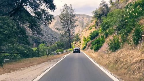 Blick durch das Autofenster auf eine Reise in die Berge Kaliforniens, Autoverkehr und Straße