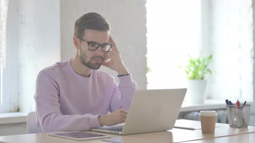 Man Working on Laptop in Bright Office Environment