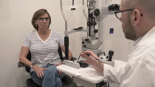 Optometrist Talking With Patient In Exam Room