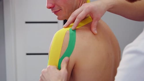 Kinesiology Tape Applied to Man's Shoulder