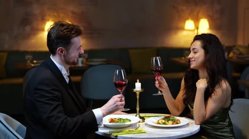 Happy Romantic Couple Clinking with Wine Glasses While Enjoying Dinner in the Restaurant Lifestyle