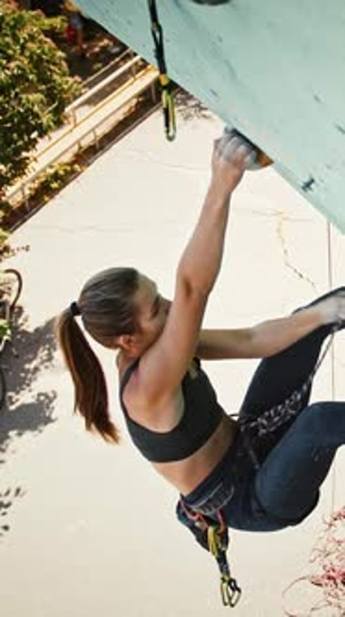 Top View on Young Female Climber Going Up at Outdoor Artificial Rock Slow Motion