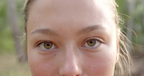 Close-up of a young Caucasian woman with hazel eyes and a subtle smile