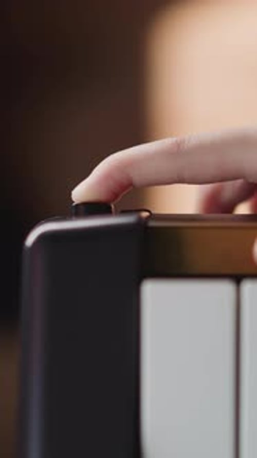 Finger Presses Power Button on Portable Device