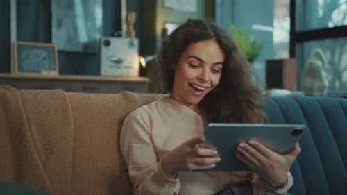 Woman Using Tablet Device on Sofa at Home