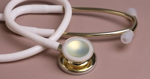 Stethoscope on beige background, spinning. closeup view