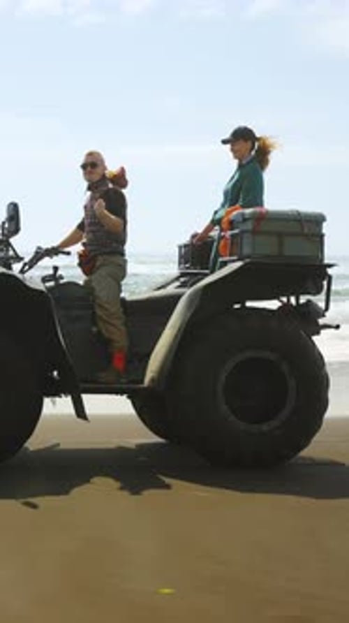 Exploring Coastal Landscapes Adventurers Riding an AllTerrain Vehicle on the Beach Enjoying the