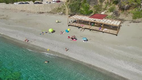 Aerial Video of Two Paddle Boarders on Calm Sea Near Rocky Coastline