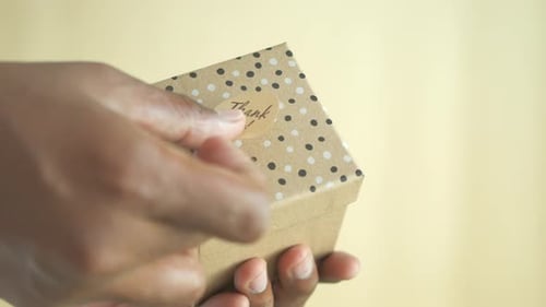 Placing Thank You Sticker on Small Gift Box
