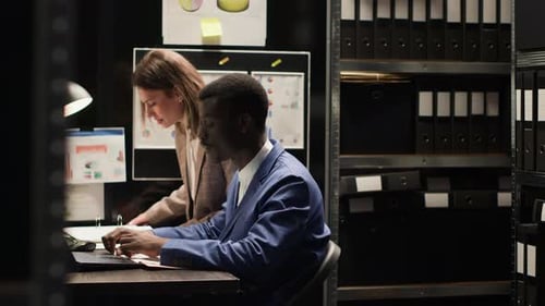 Man and Woman Collaborating in Dark Office