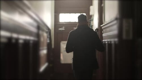 Persona que sale de su casa saliendo por el pasillo hacia la acera de la ciudad y sale