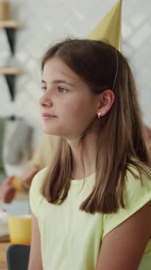 Celebração de aniversário alegre com uma jovem feliz usando um chapéu de festa colorido