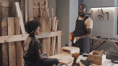 Father Showing Son How to Drill Nails during Crafting