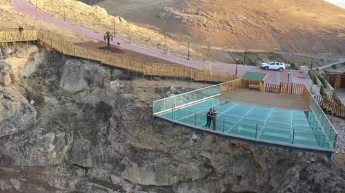 Aerial View Of Couple Enjoying The View On The Glass Terrace On The Hill