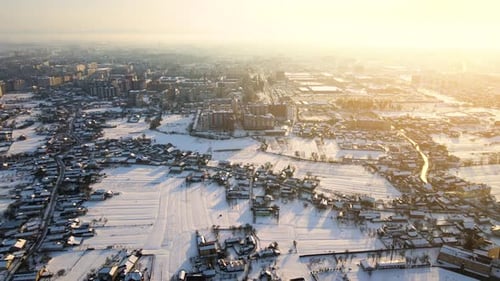 Aerial View of Residential Houses with Snow Covered Roofops in Suburban Rural Town Area in Winter