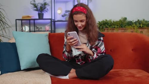 Girl Counts Money and Uses Cell Phone