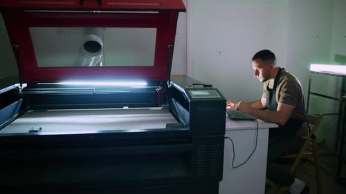 Techniker bedient Lasergravurmaschine in der Werkstatt