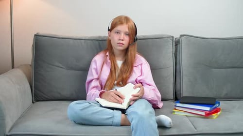 Homeschooling Online By Videocall Distance Learning Redhaired Girl Sitting on the Couch in Living
