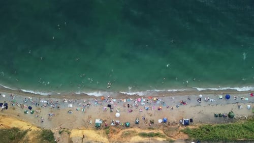 Aerial View of Sandy Beach Swimming People in Sea Bay with Transparent Blue Water at Sunset in