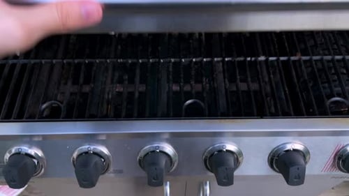 Hand opens an empty grill. 24fps