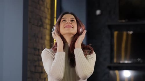 Happy Woman Listening and Testing Headphones in Store Shop or Department Store