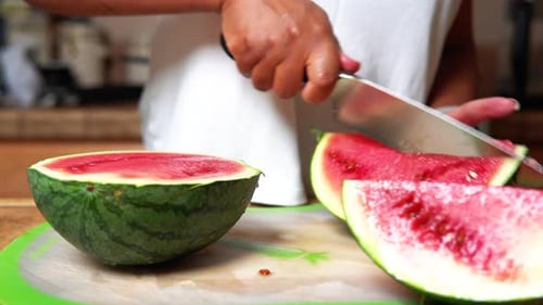 Slicing big wedges of home garden grown watermelon ripe, sweet and juicy