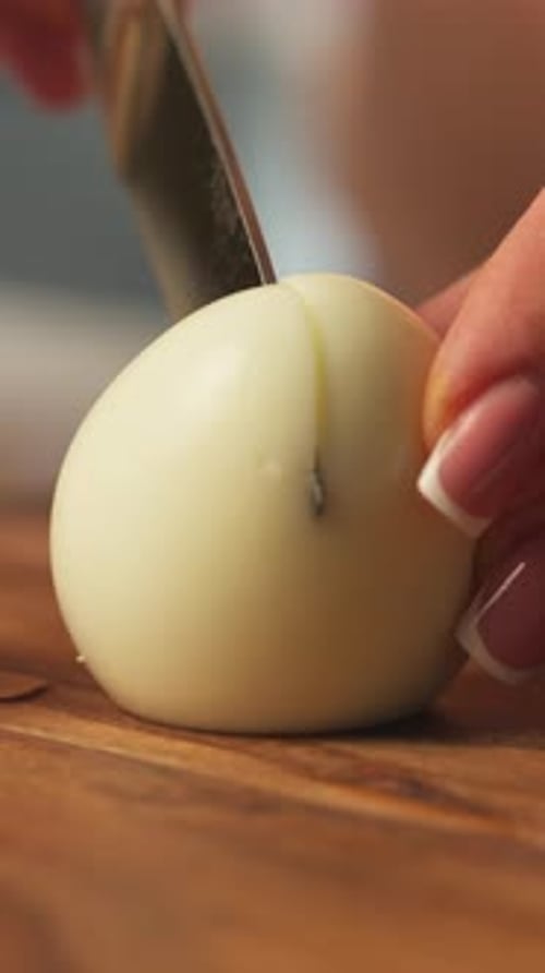Egg Being Cut on Wooden Board
