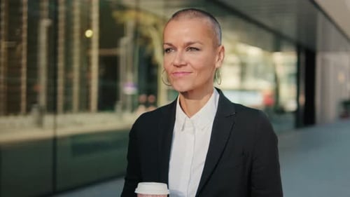 Portrait of Confident Businesswoman Walks City Street With Coffee