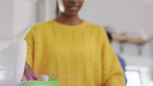 African american woman recycling waste in kitchen