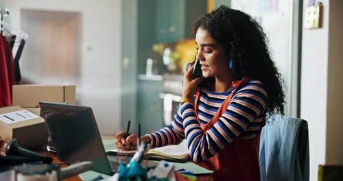 Woman on Phone Taking Notes at Desk