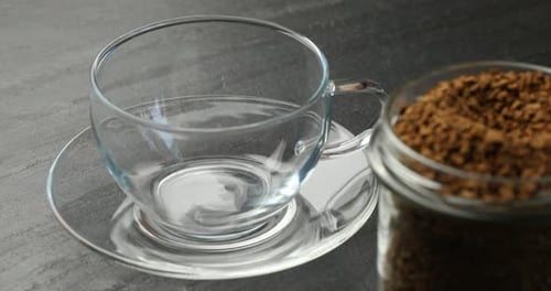 Preparing Coffee: Spooning Granules into Clear Glass Cup