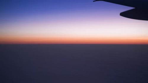 Airplane window view. Landscape of dusk above dark horizon.