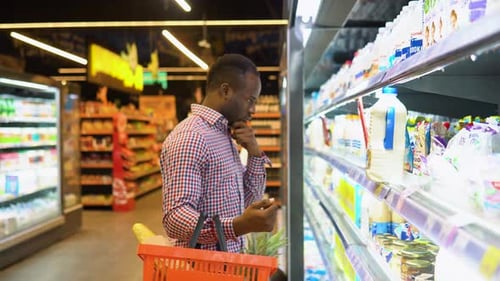 Handsome Black Man Buying Milk in Grocery Store