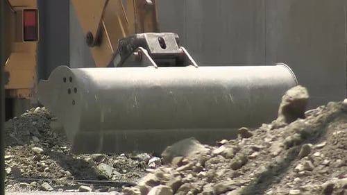 Digger Lifting Soil on Construction Site