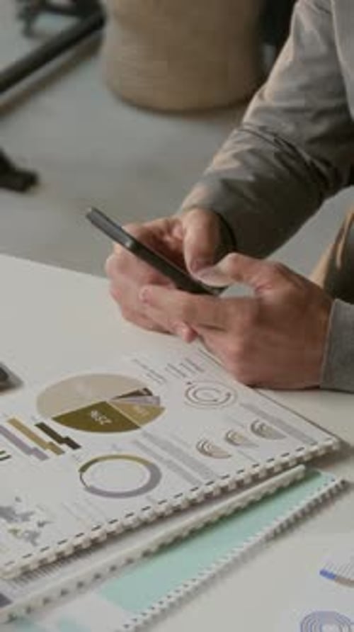 Man Using Smartphone with Financial Charts