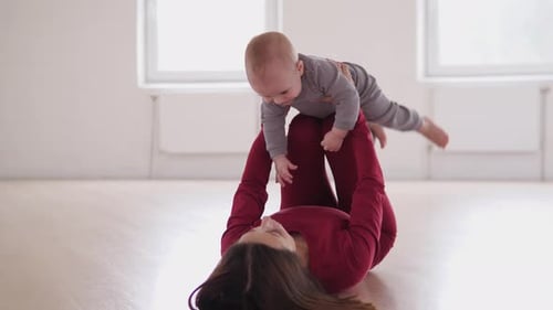 Mother Exercises with Infant in Bright, Spacious Room
