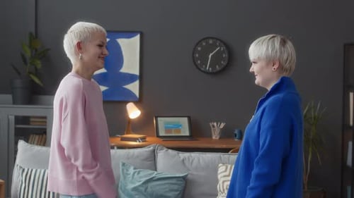 Two Friends Talking and Gesturing Indoors