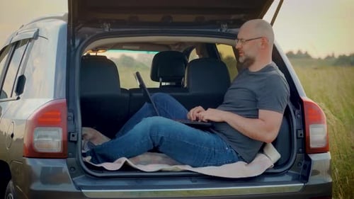 Empresário contemporâneo sério falando por videochamada trabalhando remotamente em um laptop sentado