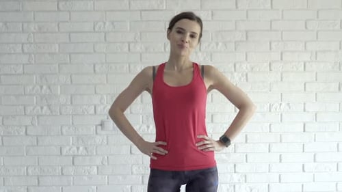 Porträt einer glücklichen, sportlichen Frau, die zu Hause auf der Matte steht, 30er Jahre