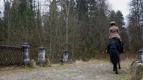 Monter à cheval dans le vieux jardin royal, cavalière dans un costume de jockey historique vintage, vue arrière